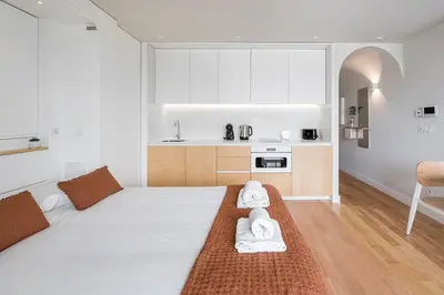 a bedroom with a large bed and a kitchen at GuestReady - A lovely retreat in Porto in Porto