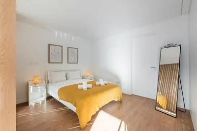 a bedroom with a large bed and a mirror at GuestReady - One perfect home near Marquês in Porto