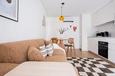 a living room with a couch and a table at Povoa Terrace, A Curated Escape with Large Balcony in Porto
