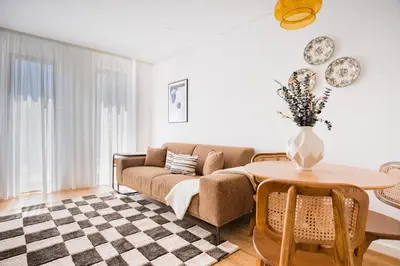 a living room with a couch and a table at Povoa Terrace, A Curated Escape with Large Balcony in Porto