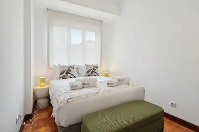 a bedroom with a large white bed with a window at GuestReady - Porto stay with outdoor charm in Porto