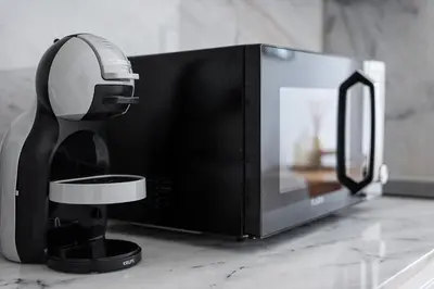 a black coffee maker on a counter next to a microwave at GuestReady - Urban paradise in Porto in Porto
