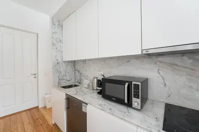 a kitchen with white cabinets and a microwave on a counter at GuestReady - Urban paradise in Porto in Porto