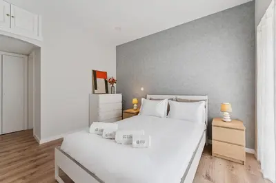 a white bedroom with a large white bed with white pillows at GuestReady - Lovely family home in Boavista in Porto