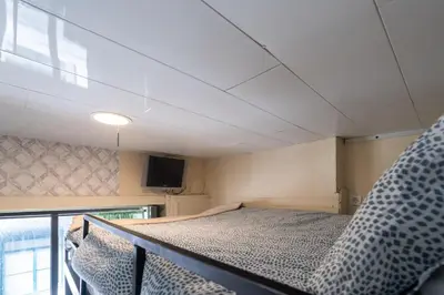 a small room with a bed and a tv at Microloft in the heart of Porto in Porto