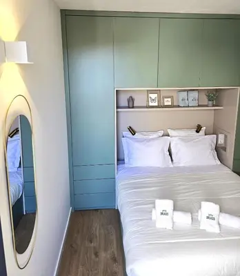 a bedroom with a large white bed with a mirror at Le Bourgeois in Porto