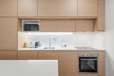 a kitchen with wooden cabinets and a sink at GuestReady - Marble Root in Porto