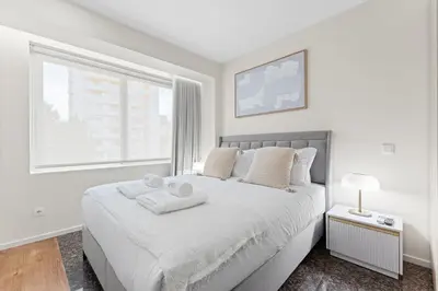a white bedroom with a bed with two towels on it at GuestReady - Marble Root in Porto