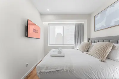 a bedroom with a large white bed with a window at GuestReady - Marble Root in Porto