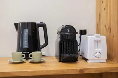 a counter with cups and a coffee maker and a toaster at Liiiving in Porto - Downtown Comfort House in Porto