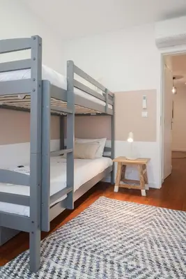 a bedroom with two bunk beds and a rug at Liiiving in Porto - Downtown Comfort House in Porto