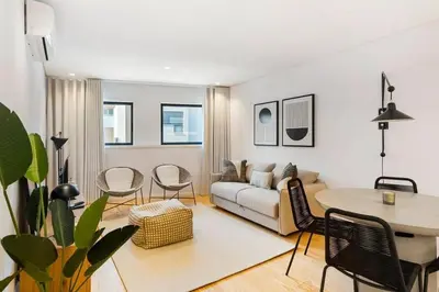 a living room with a couch and a table and chairs at Stylish Flat with Balcony, In Central Porto in Porto