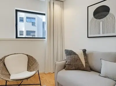a living room with a couch and a chair at Stylish Flat with Balcony, In Central Porto in Porto