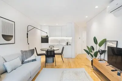 a white living room with a couch and a table at Stylish Flat with Balcony, In Central Porto in Porto
