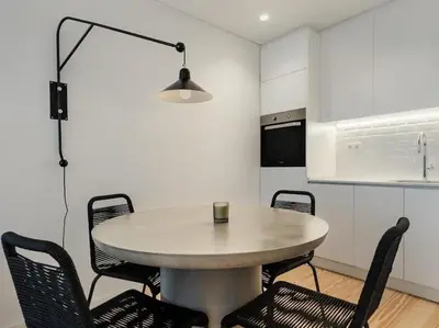 a table and chairs in a kitchen with a table and a light at Stylish Flat with Balcony, In Central Porto in Porto