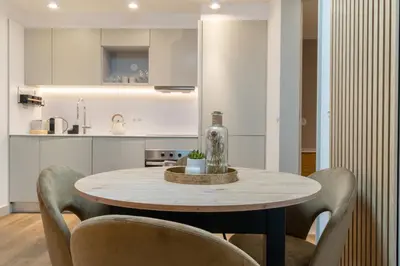 a table in a kitchen with chairs and a bottle at Modern 1BR Apartment - Brand New Bonjardim F in Porto