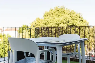 two white chairs and a table on a balcony at GuestReady - One Step Closer in Porto