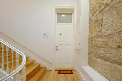 a hallway with a white door and a stone wall at Bright 2bedroom apartment in Bonfim, 2 minutes from Campanhã, Porto city center in Porto