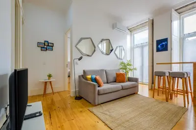 a living room with a couch and a tv at Bright 2bedroom apartment in Bonfim, 2 minutes from Campanhã, Porto city center in Porto