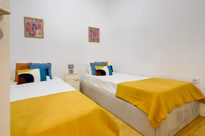 two beds sitting next to each other in a room at Bright 2bedroom apartment in Bonfim, 2 minutes from Campanhã, Porto city center in Porto