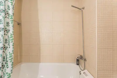 a shower with a white tub in a bathroom at GuestReady - Cosy Studio Near Arrábida Shopping in Vila Nova de Gaia