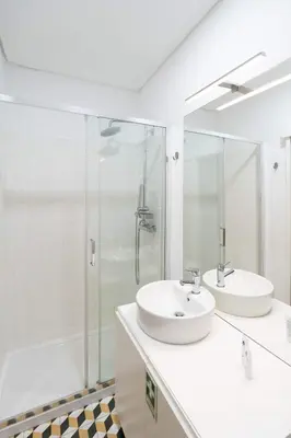 a white bathroom with two sinks and a shower at Colorful & Cozy Apartment by HostWise in Porto