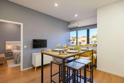 a kitchen and living room with a table and chairs at Colorful & Cozy Apartment by HostWise in Porto