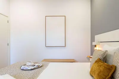 a white bedroom with a bed and a picture on the wall at Colorful & Cozy Apartment by HostWise in Porto