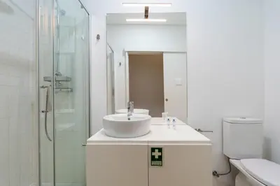 a white bathroom with a sink and a shower at Colorful & Cozy Apartment by HostWise in Porto