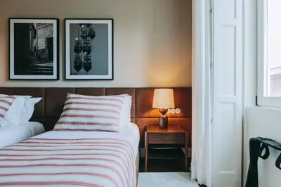 a bedroom with a bed and a table with a lamp at Gran Cruz Apartments in Vila Nova de Gaia