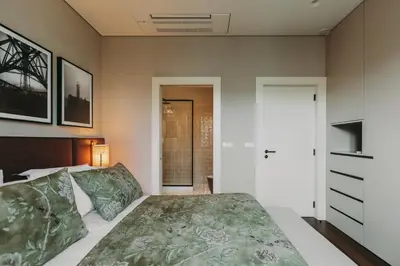 a bedroom with a large bed and a door at Gran Cruz Apartments in Vila Nova de Gaia