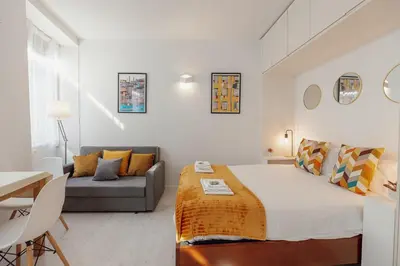 a white bedroom with a bed and a couch at Downtown Formosa Studio by Vacationy in Porto