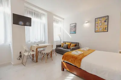 a bedroom with a bed and a table and a couch at Downtown Formosa Studio by Vacationy in Porto