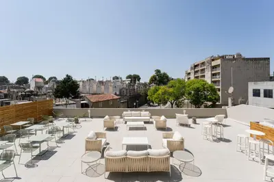 a table with chairs and a bowl of fruit on it at Bom Sucesso Executive Flats by Feel Porto in Porto