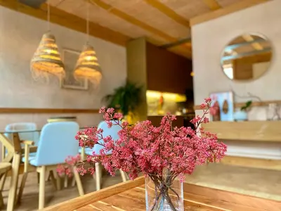 a vase filled with pink flowers sitting on a table at Paraíso Garden Apartments in Porto