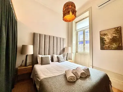 a bedroom with a bed with two towels on it at Paraíso Garden Apartments in Porto