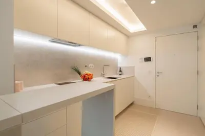 a kitchen with white cabinets and a white counter top at Stylish Formosa Studio by HostWise in Porto