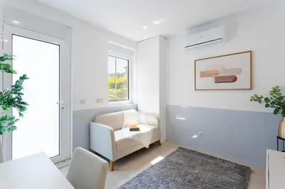 a white living room with a chair and a window at Authentic Retreat by HostWise in Porto