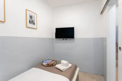 a white room with a bed and a tv on a wall at Authentic Retreat by HostWise in Porto
