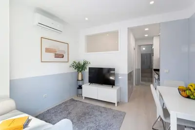 a white living room with a television and a table at Authentic Retreat by HostWise in Porto
