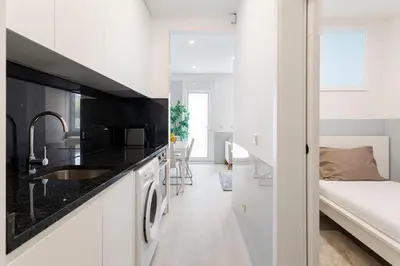 a white kitchen with black countertops and a bedroom at Authentic Retreat by HostWise in Porto