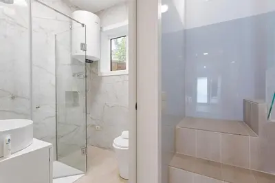 a white bathroom with a shower and a toilet at Authentic Retreat by HostWise in Porto