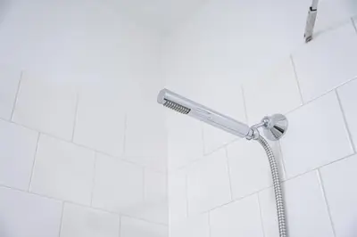 a shower head in a bathroom with white tiles at Historic Porto Flat, Central Porto in Porto