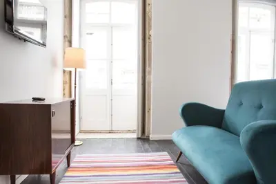 a living room with a blue couch and a table at Porto República Suites in Porto