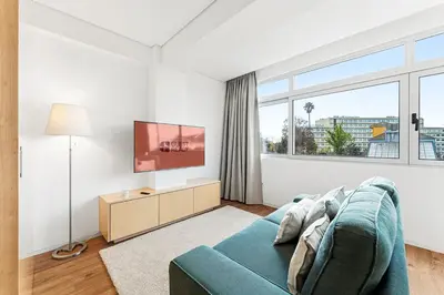 a living room with a blue couch and a tv at GuestReady - Urban comfort in Boavista in Porto