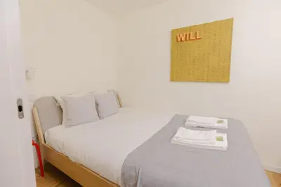 a bedroom with a bed with a wall with the word will on it at Trindade Skyline Premium by Hosty in Porto