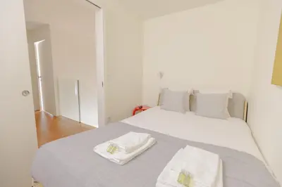 a white bed with two towels on top of it at Trindade Skyline Premium by Hosty in Porto