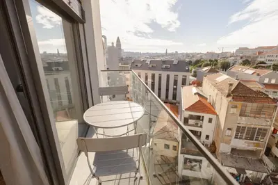 a balcony with a stool and a view of a city at Trindade Skyline Premium by Hosty in Porto