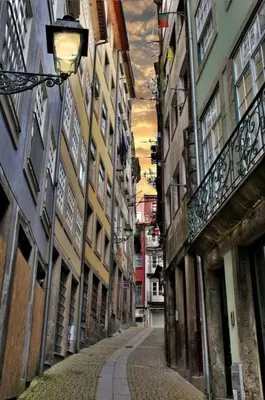 an empty alley with buildings and a street light at Historical Porto Apartment in Porto