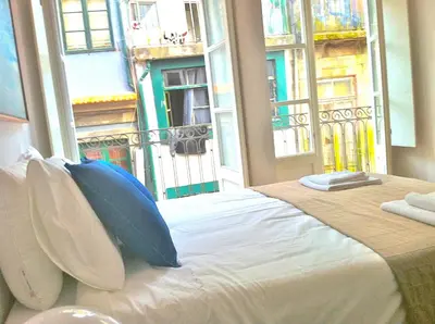 a bedroom with a large bed with a large window at Historical Porto Apartment in Porto